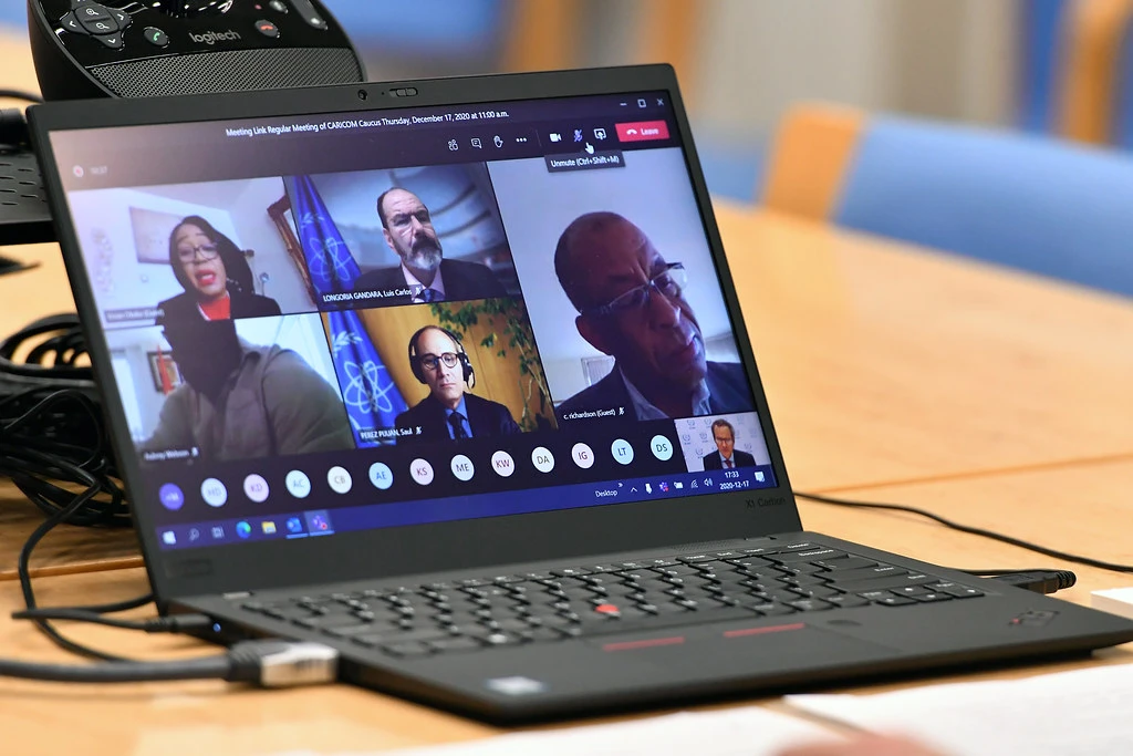 Laptop on desk displaying a multi-person video conference call.
