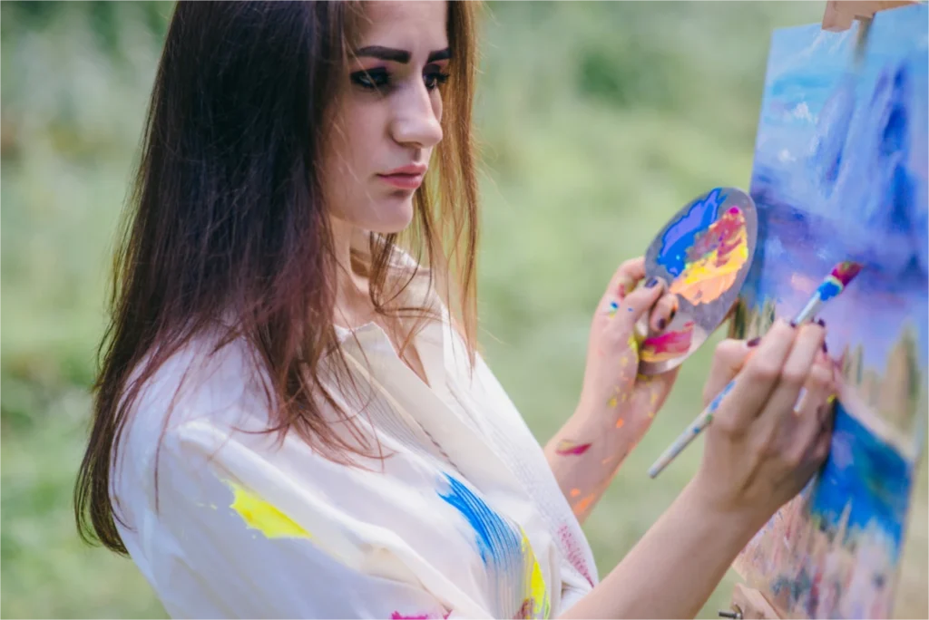 Woman painting on a canvas.