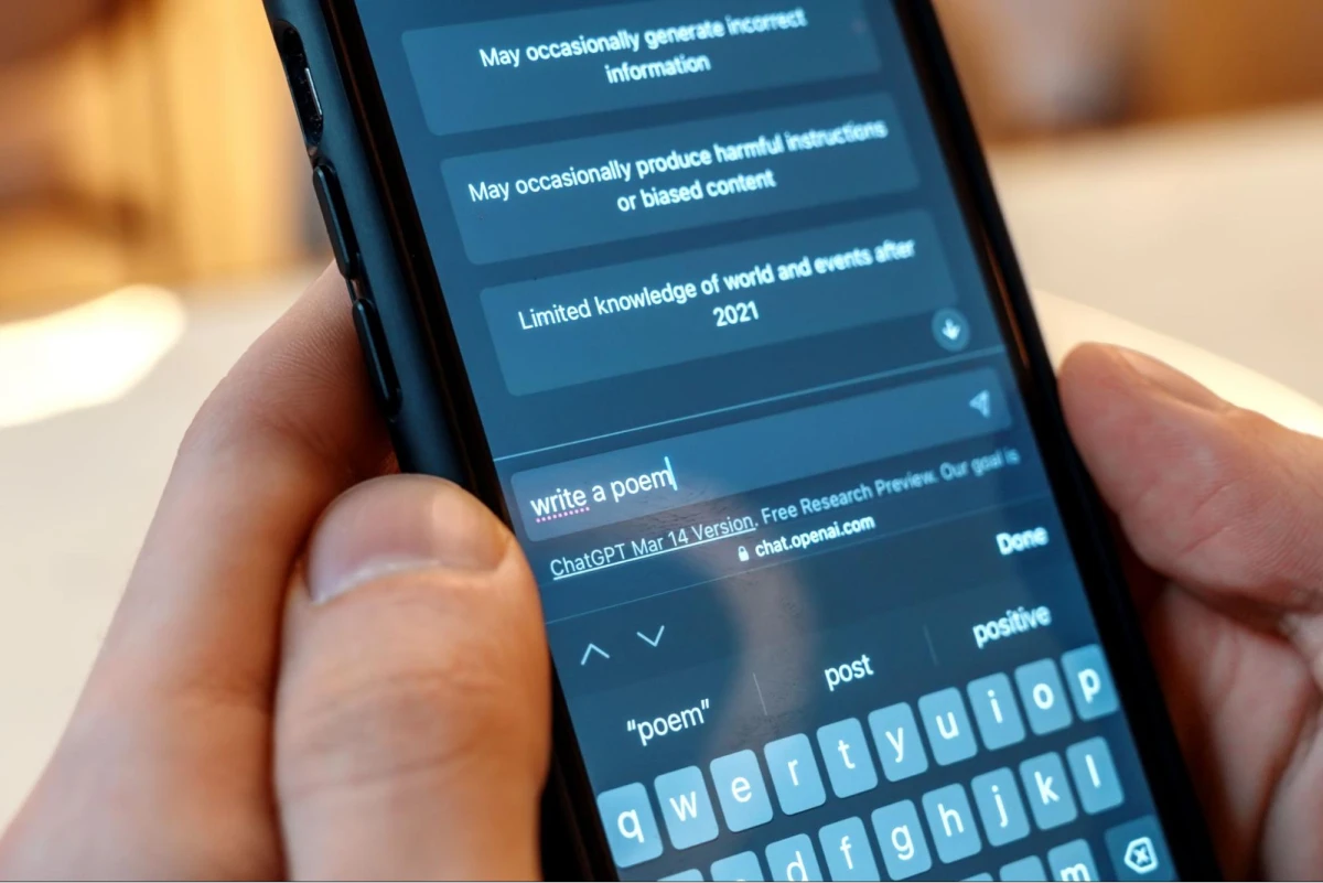 Hand typing 'write a poem' on phone