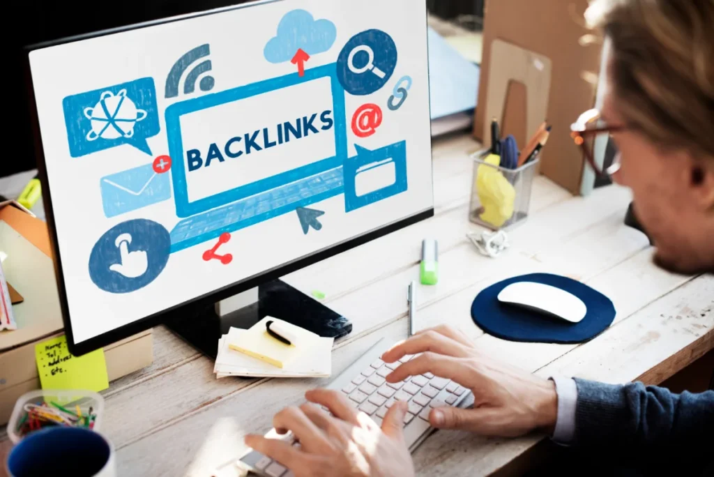 A person working on a computer with a 'Backlinks' graphic displayed on the screen, symbolizing SEO.